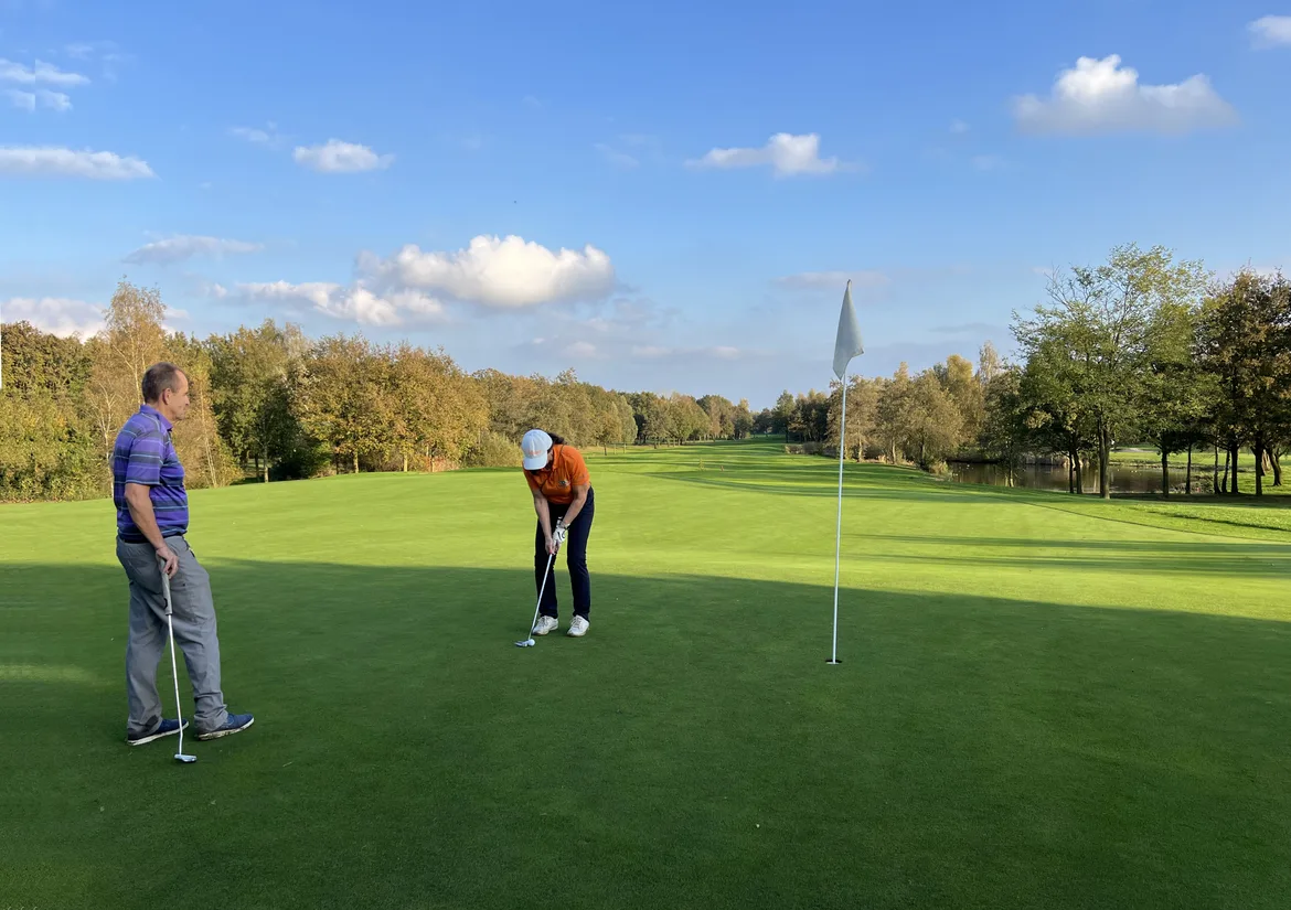 Een man en vrouw putten hole 14 uit