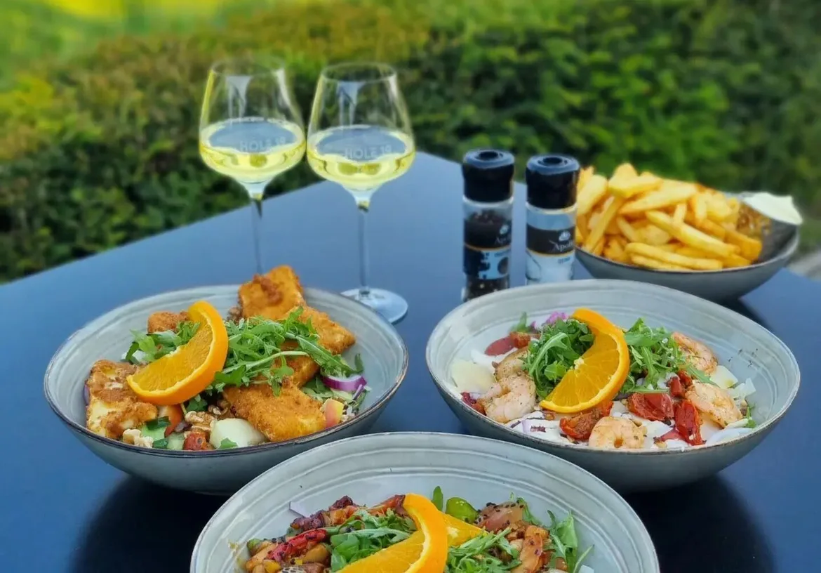 Maaltijdsalade met witte wijn op het terras van Hole 19