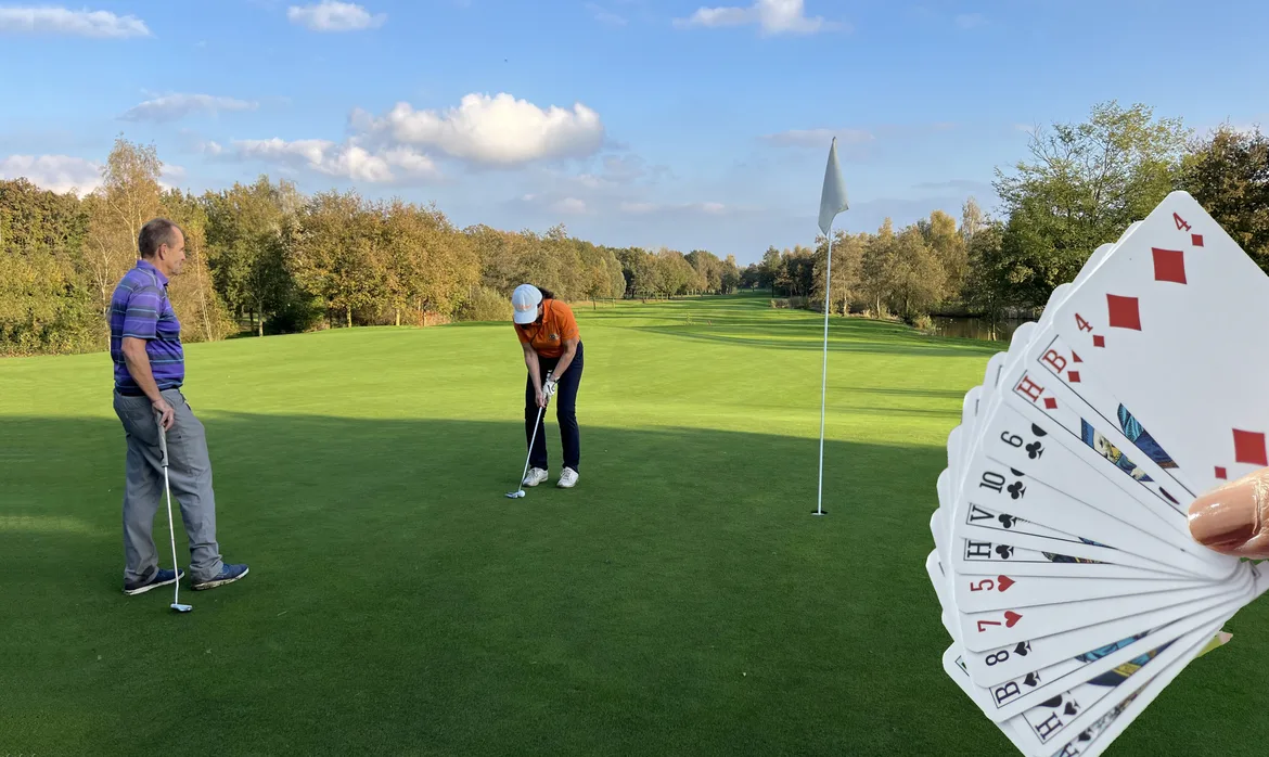 golfers op de green en een hand bridge kaarten in beeld