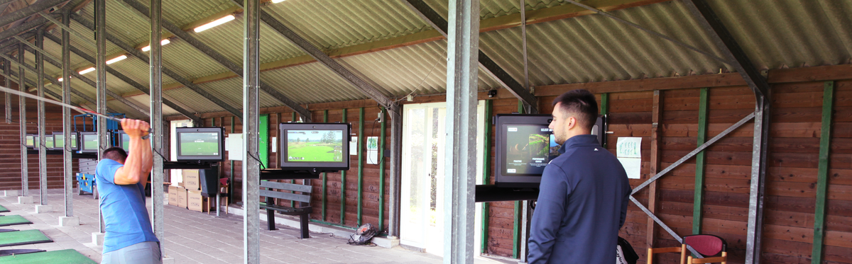 twee golfers op de driving range met Trackman