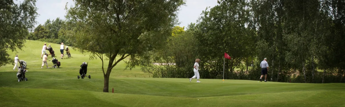 golfers op de green van hole 7 en onderweg op hole 8
